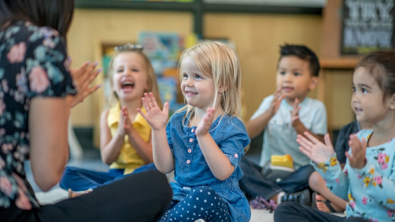 Kids interacting and waving at teacher.